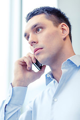 Image showing serious businessman with smartphone