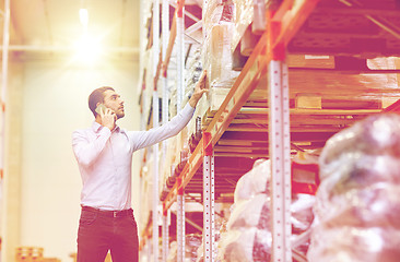 Image showing serious man calling on smartphone at warehouse