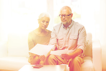 Image showing senior couple with papers and calculator at home