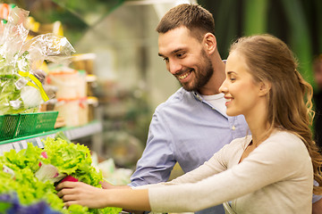 Image showing happy couple buying lettuce at grocery store