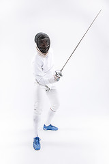 Image showing Man wearing fencing suit practicing with sword against gray