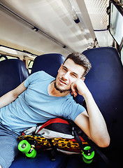 Image showing young pretty modern hipster guy traveller on train with skateboa