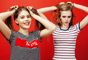 Image showing two best friends teenage girls together having fun, posing emotional on red background, besties happy smiling, lifestyle people concept 