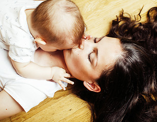 Image showing young brunette happy mother holding toddler baby son, breast-fee