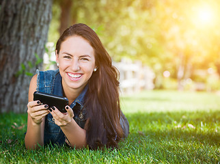 Image showing Mixed Race Young Female Texting on Cell Phone Outside In The Gra