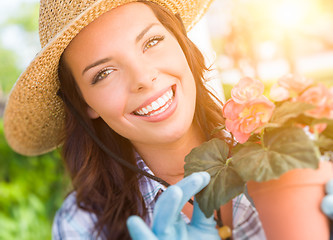 Image showing Young Adult Woman Wearing Hat and Gloves Gardening Outdoors