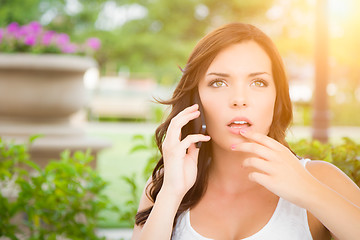 Image showing Shocked Young Adult Female Talking on Cell Phone Outdoors