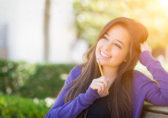 Image showing Pensive Mixed Race Female Student with Pencil on Campus