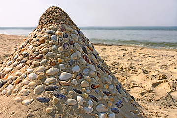 Image showing Sandy pyramid with shells on a sea beach