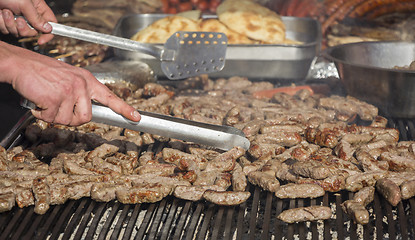 Image showing Grilling cevaps or kebabs on a grill at the street market