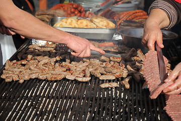 Image showing Grilling cevaps or kebabs on a grill at the street market