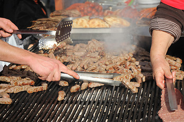 Image showing Grilling cevaps or kebabs on a grill at the street market