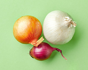Image showing various onions on green background