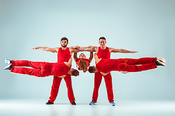 Image showing The group of gymnastic acrobatic caucasian men on balance pose