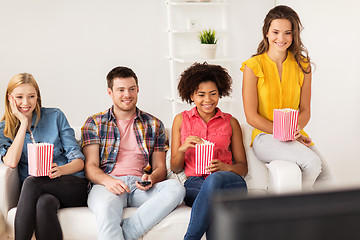 Image showing happy friends with popcorn watching tv at home