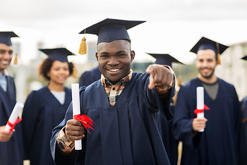 Image showing happy student with diploma pointing finger at you