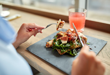 Image showing woman eating prosciutto ham salad at restaurant