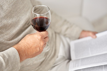 Image showing close up of senior man with wine glass and book