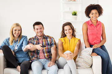 Image showing happy friends with remote watching tv at home