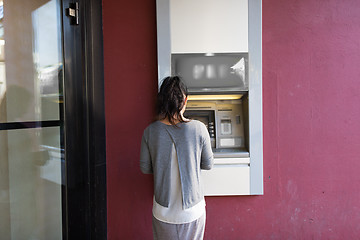 Image showing close up of woman at atm machine outdoors