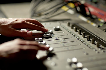 Image showing hands on mixing console in music recording studio