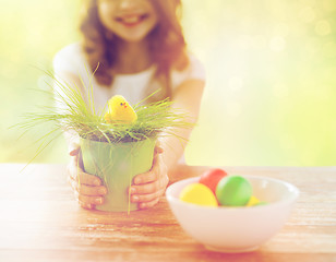 Image showing close up of girl holding pot with toy chicken