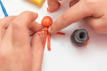 Image showing Children\'s hands molded man from clay