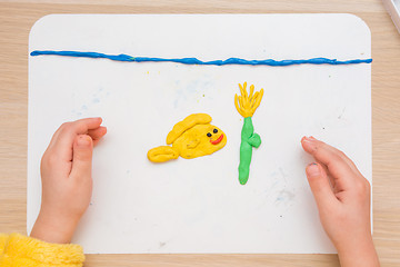 Image showing Child blinded pas board for modeling fish and underwater flower in the sea, the top view