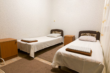 Image showing The interior of a small room with two beds