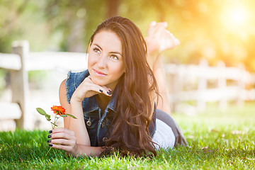 Image showing Attractive Mixed Race Girl Holding Flower Portrait Laying in Gra