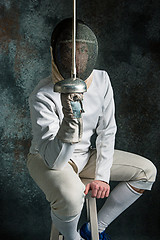Image showing The man wearing fencing suit with sword against gray