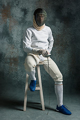 Image showing The man wearing fencing suit with sword against gray