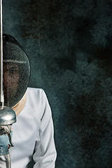 Image showing The man wearing fencing suit with sword against gray