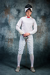 Image showing The woman wearing fencing suit with sword against gray