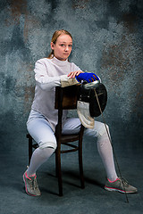 Image showing The woman wearing fencing suit with sword against gray