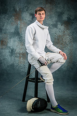 Image showing The man wearing fencing suit with sword against gray