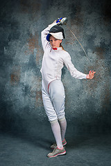 Image showing The woman wearing fencing suit with sword against gray