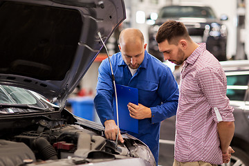 Image showing auto mechanic with clipboard and man at car shop