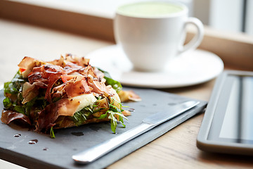 Image showing prosciutto ham salad on stone plate at restaurant