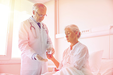 Image showing doctor giving medicine to senior woman at hospital