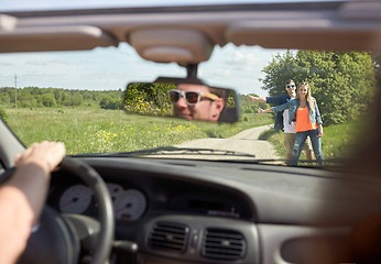 Image showing couple hitchhiking and stopping car on countryside