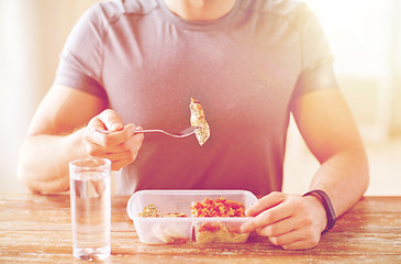 Image showing close up of man with fork and water eating food