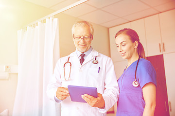 Image showing senior doctor and nurse with tablet pc at hospital