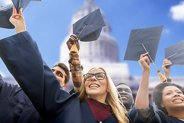 Image showing happy students or bachelors waving mortar boards