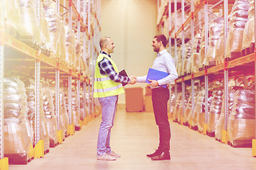 Image showing worker and businessmen with clipboard at warehouse