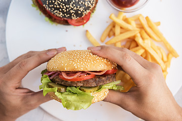 Image showing Man eating burgers