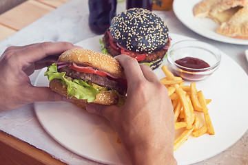 Image showing Man eating burgers