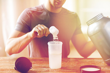 Image showing close up of man with protein shake bottle and jar