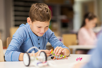 Image showing close up of boy building robot at robotics school