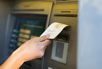 Image showing close up of hand taking receipt from atm machine